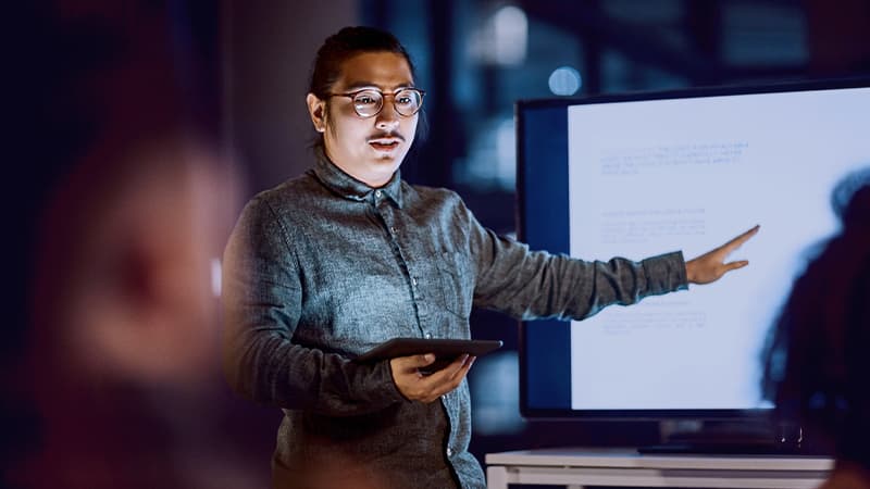 Shot Of A Young Businessman Delivering A Presentation During A Late Night Meeting At Work